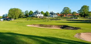 fågelbro golf grön golfbana med vita hus i bakgrunden